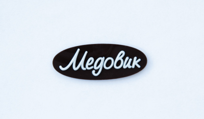 Декор Фигурный темный  Логотип "Медовик"(овал) с надписью из белой глазури  ТG-0028